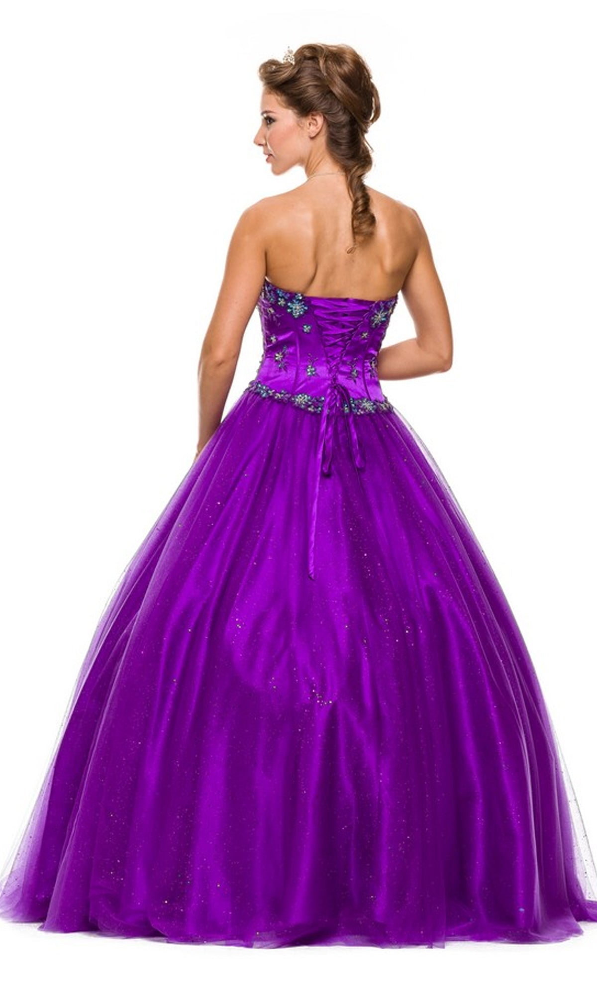 A woman stands facing away from the camera wearing the Juliet 332 long prom dress, a strapless, floor-length purple ball gown adorned with floral embellishments.